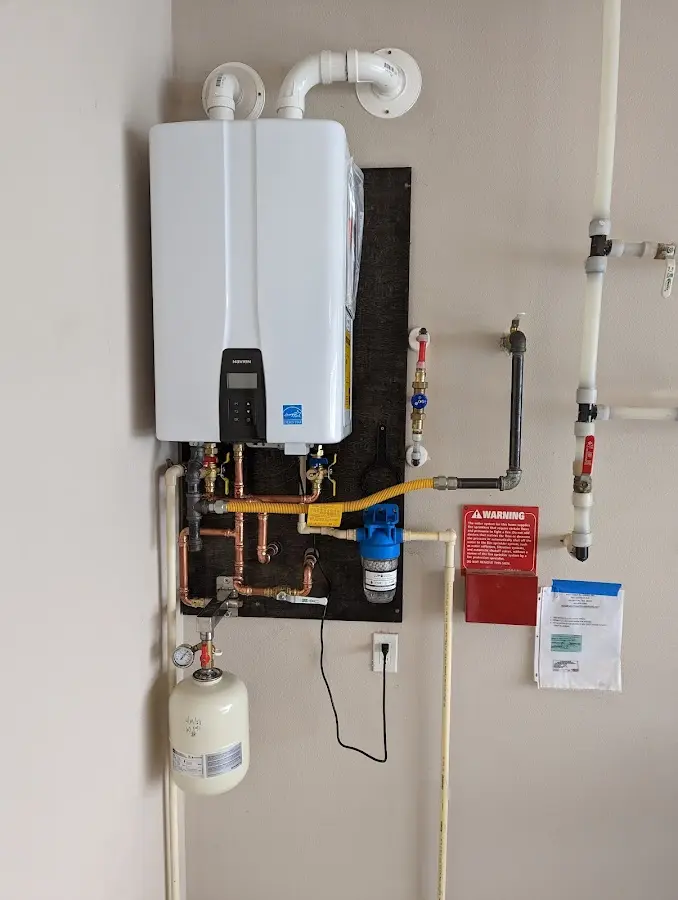 Professional plumber installing copper piping in a Phelps home